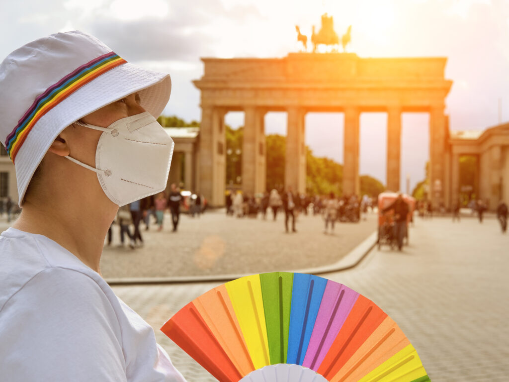 Queer traveler near Brandenburg Gate in Berlin, Germany (Photo Credit: anyaivanova / iStock)